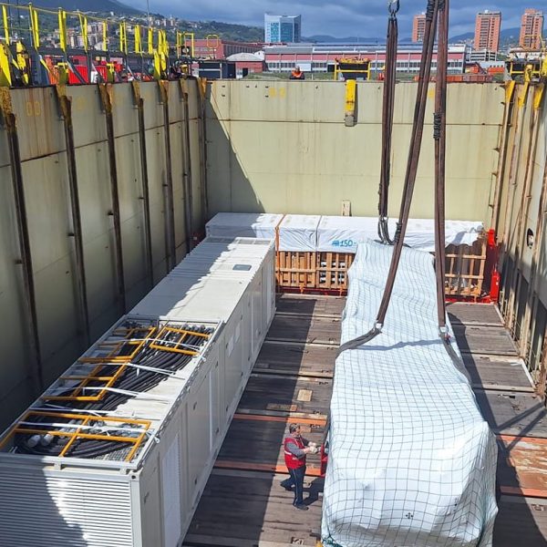Large industrial trailers and cargo containers arranged inside the ship's hold.