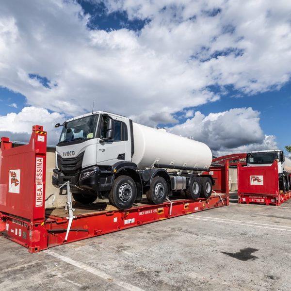 An Iveco T-Way tanker truck secured on a red flatrack container ready for shipping.
