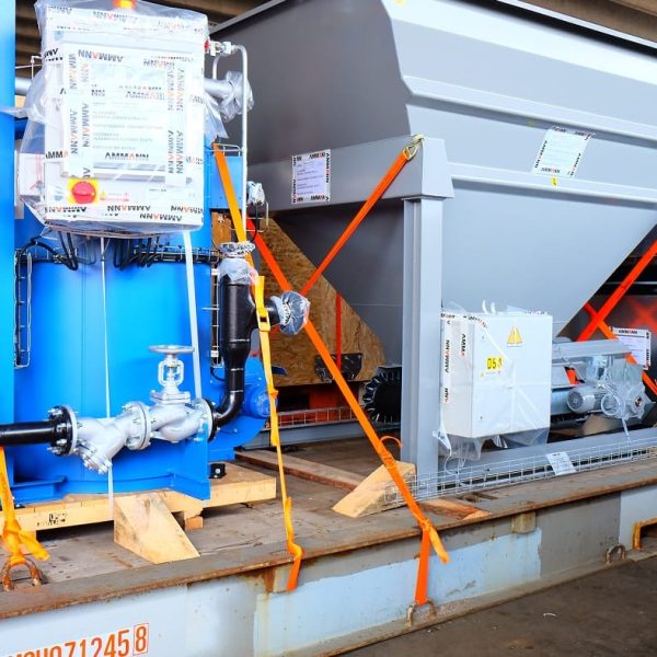 Technical machinery and a blue industrial tank for the Ammann plant secured with orange straps.