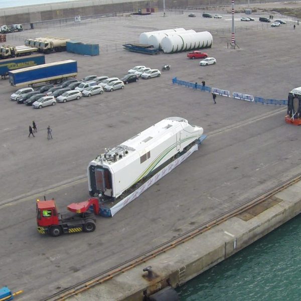 Aerial view of the port area as a tractor unit moves a Talgo locomotive toward the ship.