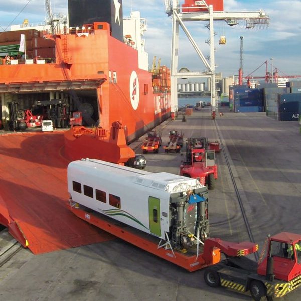 A Talgo car being reversed up the massive orange ramp of the Jolly Quarzo.