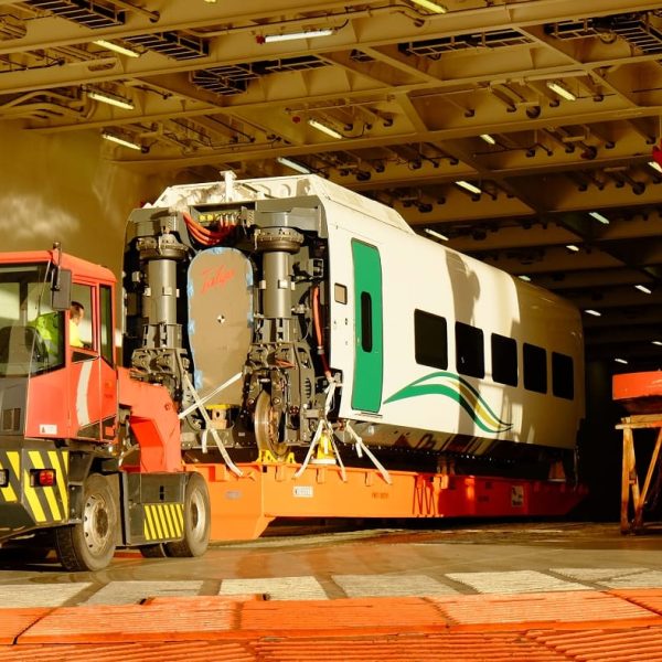 Close-up of a Talgo train car secured on a roll-trailer inside the ship's illuminated hold.